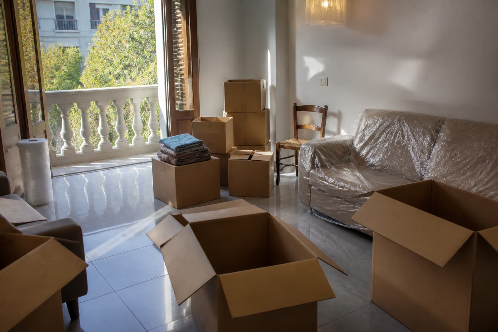 Cajas de mudanza abiertas en un piso de Valencia, con luz de balcón.